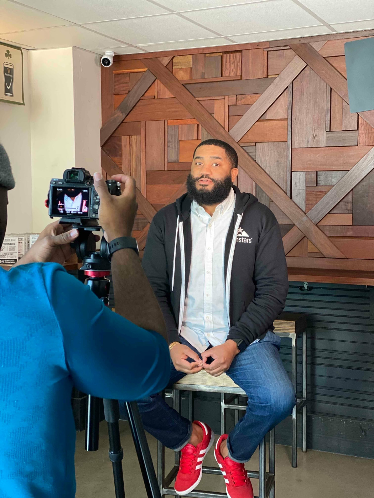 Jerold McDonald seated on a stool while being filmed for an interview